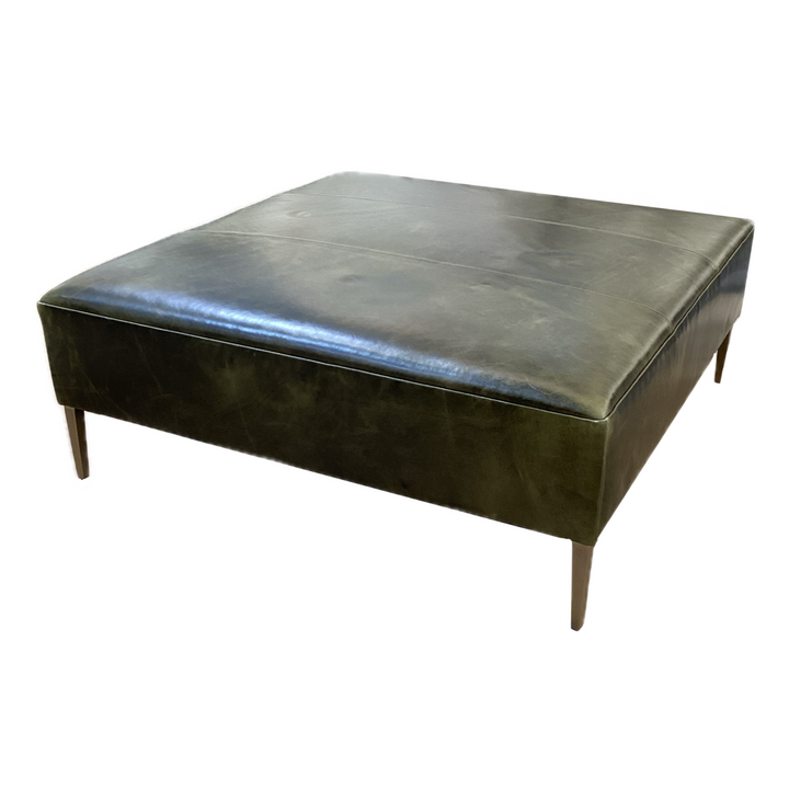 Square ottoman with leather top on a white background